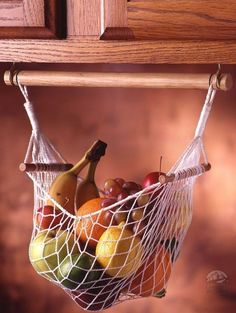 a fruit basket hanging from a wooden shelf