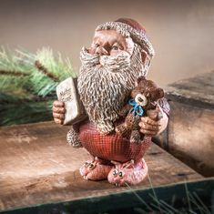 a statue of an old man with a beard holding a book and two teddy bears