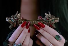 a woman with red nails holding a dragon handle