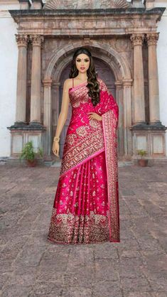 a woman in a pink and gold sari