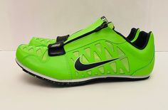 a pair of green nike shoes with black and white details on the upper part of the shoe