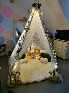 a white tent with candles and lights on it in the middle of a living room