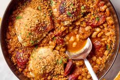 a pan filled with beans and meat covered in sauce