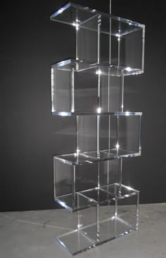 a stack of clear cubes sitting on top of a white floor next to a black wall