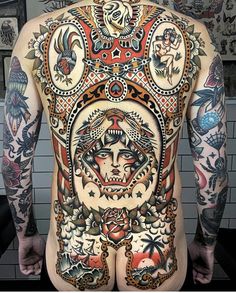 the back of a man's body with many tattoos on his chest and arms