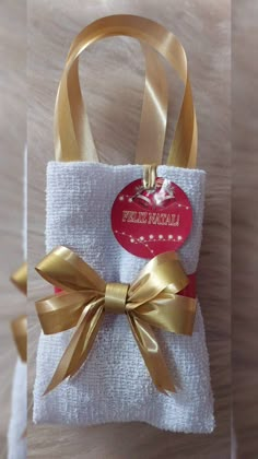 a small white bag with a gold bow on it