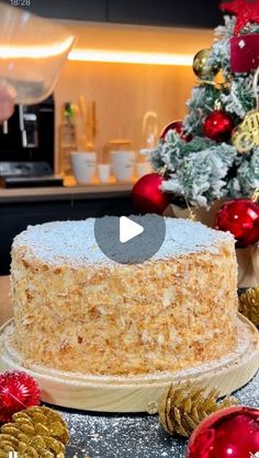 a cake sitting on top of a table covered in frosting next to christmas decorations