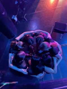 a group of women standing in a circle on top of each other at a concert