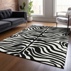 a black and white rug with zebra print on the floor in front of a couch