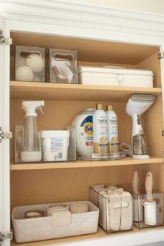 an open cabinet filled with lots of cleaning supplies