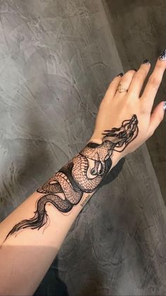 a woman's arm with a tattoo on it and a dragon on the wrist