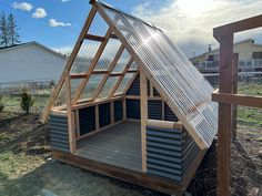 a small house made out of metal and wood with a roof that is attached to the side of it