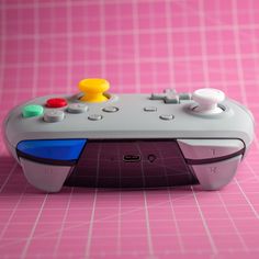 a video game controller sitting on top of a pink table