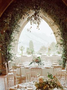 an outdoor wedding venue with tables and chairs set up for a formal function in front of an arched doorway