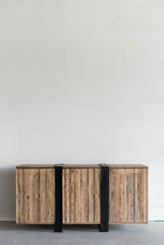 two wooden cabinets sitting next to each other on top of a cement floor in front of a white wall