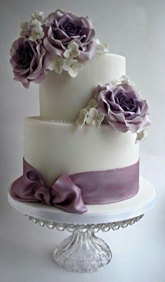 a three tiered cake with purple flowers on top