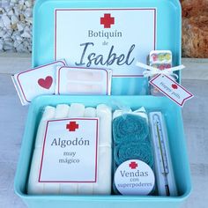 an open blue box filled with medical supplies on top of a cement floor next to rocks