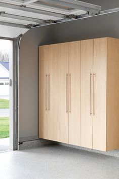 an empty garage with wooden cabinets and sliding glass doors