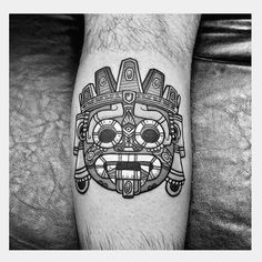 a tattoo on the leg of a man with a mask in black and white ink