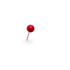 a single red button sitting on top of a white surface