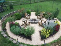 an outdoor fire pit surrounded by flowers and benches in the middle of a garden area