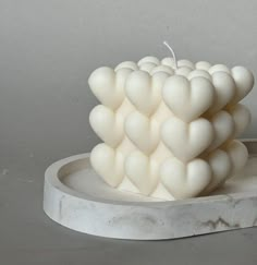 a white candle sitting on top of a marble plate