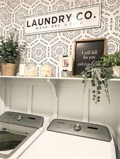 a washer and dryer sitting next to each other in front of a laundry co sign