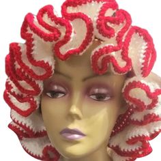 a mannequin head wearing a red and white crocheted hat with curly hair