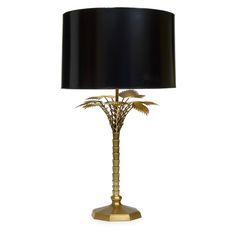 a table lamp with a black shade on the top and palm trees in the bottom