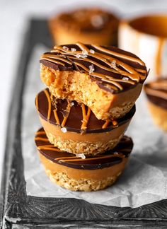 three chocolate covered donuts stacked on top of each other with caramel drizzle