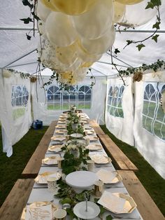 a long table set up with plates and balloons