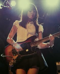 a woman playing an electric guitar on stage