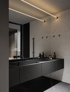 a bathroom with two sinks and black counter tops on the wall next to each other