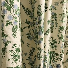 the curtains are covered with green and blue flowers