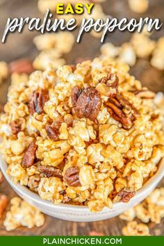 a bowl filled with granola on top of a wooden table next to pecans