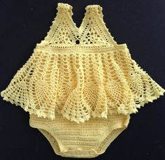 a yellow crochet baby bodysuit on a black background with the bottom part off