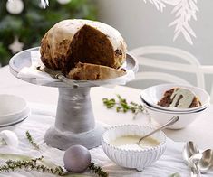 a bundt cake sitting on top of a metal stand next to plates and bowls