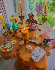 a wooden table topped with lots of different types of flowers and candles on top of it