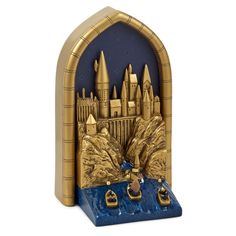 a gold and blue bookend with a castle on it