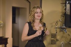 a woman in a black dress holding two champagne flutes