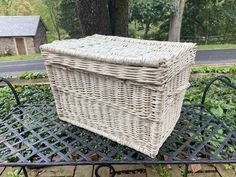 a wicker basket sitting on top of a metal bench