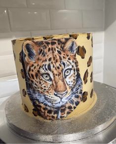 a cake decorated with an image of a leopard on it's face is sitting on top of a stove