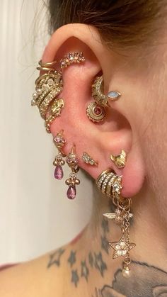 a close up of a person's ear with piercings and jewelry on it