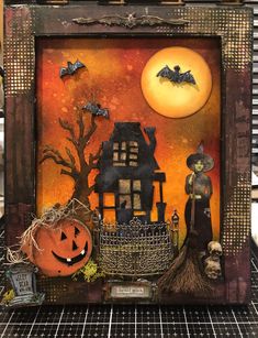 a halloween scene with pumpkins, bats and a house in the background on a shelf