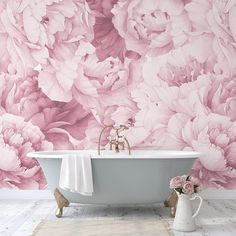 a bath tub sitting next to a wall covered in pink peonies and flowers