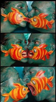 two people with painted faces and fish on their mouths