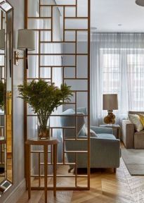 a living room filled with furniture and a tall mirror on the wall next to a window