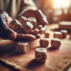 a person holding wooden dices on top of a table