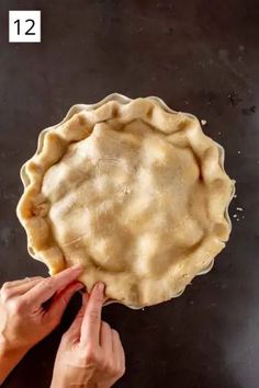 a person is placing an uncooked pie crust on top of the pie