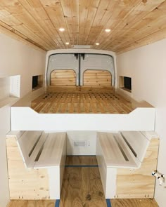 the interior of a white van with wood flooring and built - in bunk beds